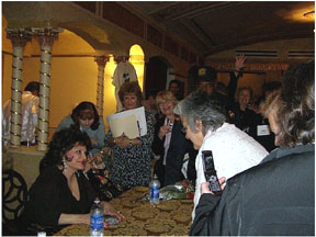 Connie signing autographs, a fan with cellphone cam