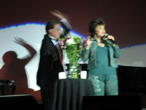 Connie on stage in pants suit outfit